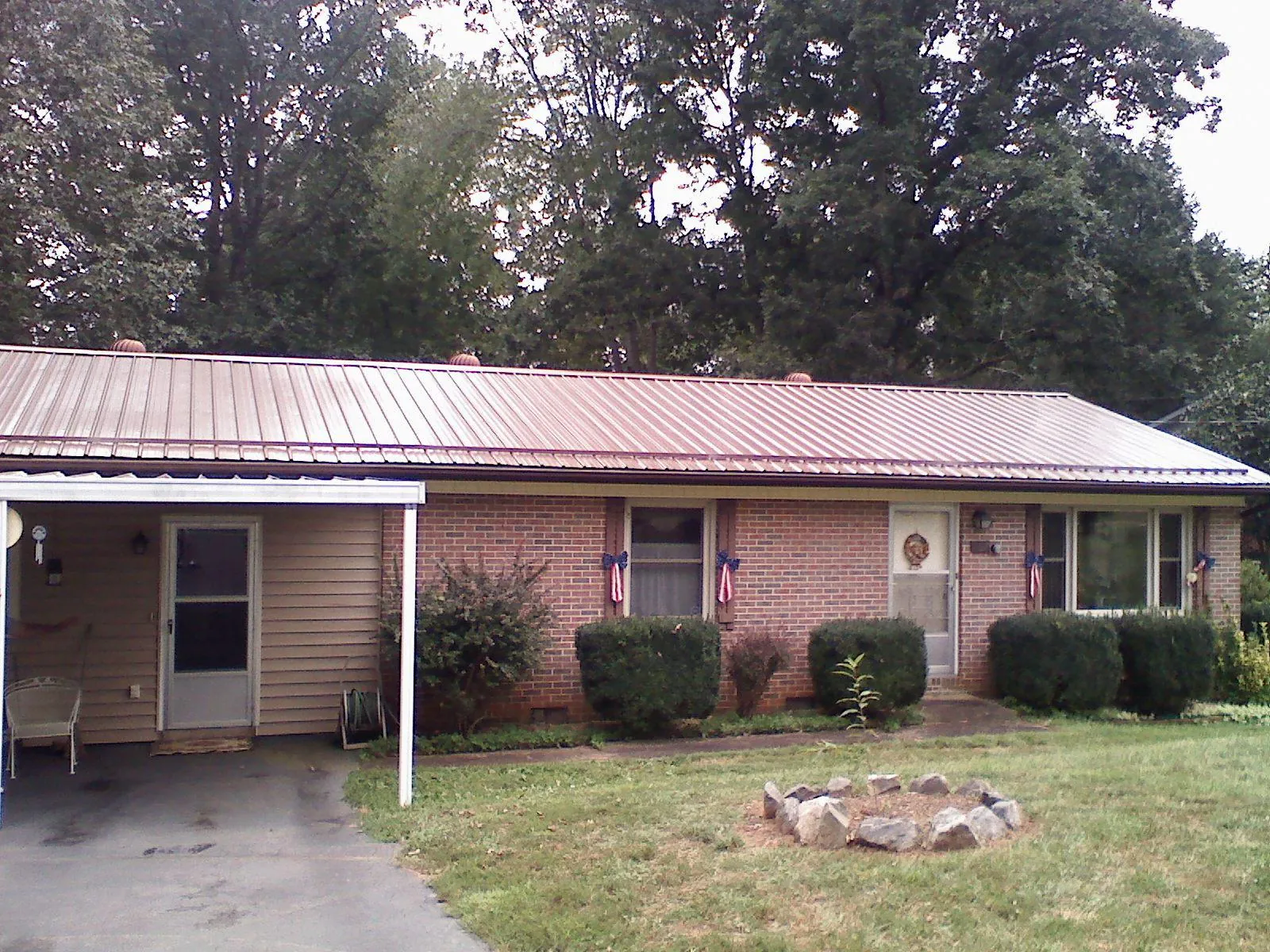 Bronze metal roof and carport on a brick ranch home — Roof Repair work by our crew in New Kent